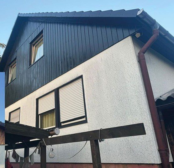 Fachmännisch gestrichene, wetterfeste Holzfassade an einem Wohnhaus