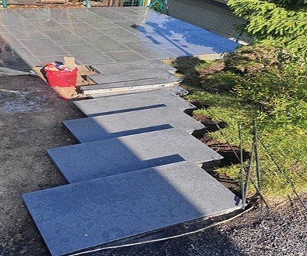 Großformatige Terrassenplatten im vorbereiteten Splittbett für einen neuen Gartenweg