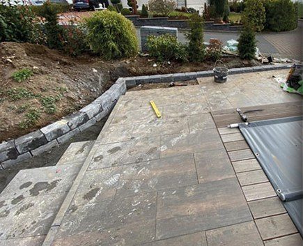 Fertig gepflasterter Vorgarten mit Randsteinen und frischer Bepflanzung