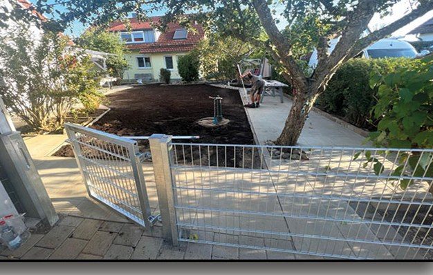 Neu montierter Metallzaun mit passendem Eingangstor an einem Wohnhaus